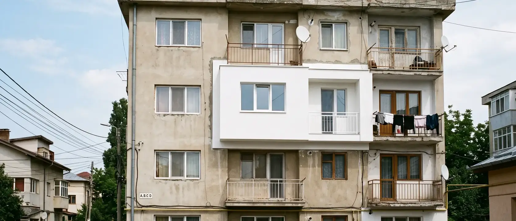 Fațadă de bloc pe care un singur apartament are termosistem, cu margini vizibile