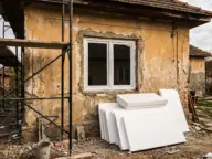 Fereastră nouă montată într-un zid încă neizolat, cu plăci de polistiren pregătite