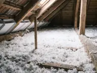 Vată minerală suflată pe planșeul podului, cu riglă pentru grosime